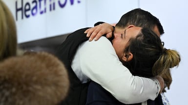 A passenger is embraced upon arrival at Heathrow International Airport after returning from the Gulf. Reuters