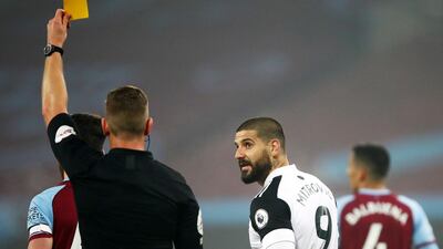 Referee Robert Jones shows yellow card to Aleksandar Mitrovic of Fulham during the match against West Ham. EPA
