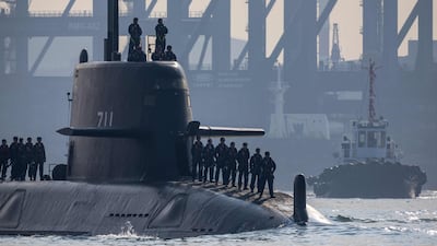 A Taiwanese Navy prototype submarine navigates towards open waters escorted by a tugboat in Kaohsiung Port, during testing operations off Taiwan. AFP