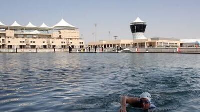 Troy Watson, a local triathlete, swims to yesterday's press conference at Yas Island.