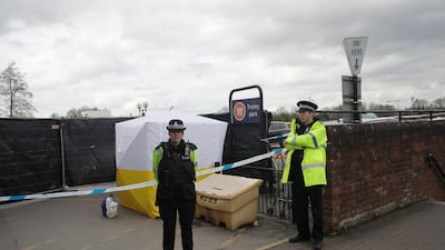 Police officers guard a cordon around a police tent covering a supermarket car park pay machine near the spot where former Russian spy Sergei Skripal and his daughter were found critically ill. AP