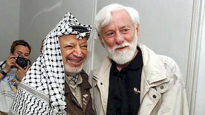 Palestinian leader Yasser Arafat poses with Uri Avnery, the head of Gush Shalom, inside his battered compound in the West Bank city of Ramallah on May 8, 2002. AFP Photo