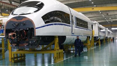 A worker walks past an almost completed high-speed train at an assembly plant of the Tangshan Railway Vehicle in China. Rolex Dela Pena / EPA