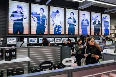 Customers browse K-pop band BTS merchandise at a souvenir store in Seoul. Bloomberg