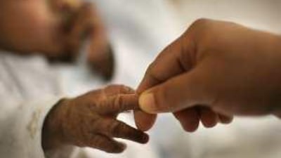 Mohammad Yousaf lies in hospital bed. The tiny tube in his nose feeds him high-calorie formula and antobiotics.