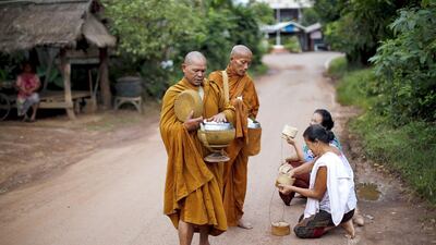 Buddhist monks receive rice from women early morning in a village outside Nong Khai, Thailand. Jorge Silva / Reuters