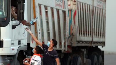 Volunteers distribute water, food and juice, to a fasting driver on a road in Egypt's Menofia governorate, during the Muslim holy month of Ramadan. AFP