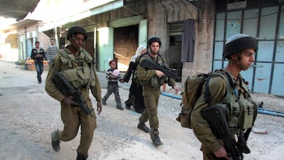 Israeli soldiers patrol the streets of downtown Hebron. Jamal Aruri