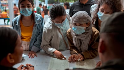 People speak with police in search of information about their missing relatives, at Tribhuvan University Teaching Hospital.