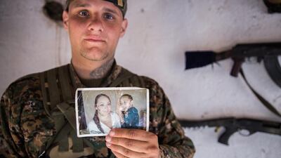 A 26-year old from the US, nick-named by Kurdish fighters as Hewal Dilsad, shows a picture of his wife and son in the outskirts of the north-western Syrian town of Tal Tamr, north of Hasakeh, near the border with Turkey, as he fights alongside People Protection Unit (YPG) fighters under the commanders, Sider and Gerzan.
