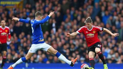 Everton defender John Stones lnges at Bastian Schweinsteiger of Manchester United during their Premier League contest at Goodison Park on Saturday. Clive Brunskill / Getty Images