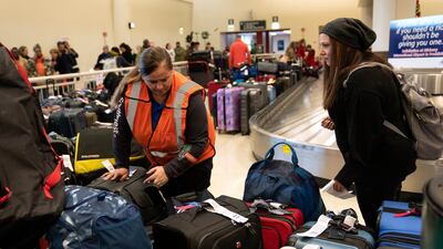 A Southwest employee helps a traveller search for bags at Midway International Airport in Chicago, Illinois. AP