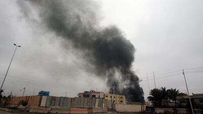 Smoke rises from a local council building destroyed by gunmen in Fallujah during a funeral in the city on Saturday. Mohamed Jalil / EPA