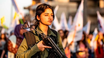 A member of the Kurdish Internal Security Police Force of Asayish stands guard as Syrian Kurdish demonstrate against Turkish threats to invade the Kurdish region in the northeastern city of Qamishli. AFP