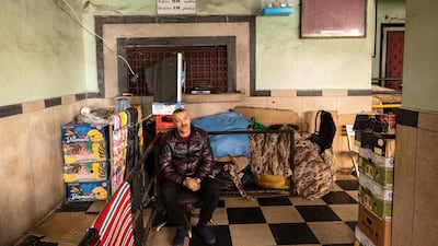 A man sits between boxes piled up at the entrance of the "Al Malaki" cinema, located in the heart of the market in the working-class neighbourhood of Derb Sultan, in the western Moroccan city of Casablanca, on January 24, 2022. - During the coronavirus pandemic, cinemas across Morocco were closed for over a year before reopening in July 2021. But despite nine million dirhams (850,000 euros) of funding for the Moroccan Centre for Cinematography (CCM), which promotes and regulates film, the industry is struggling to extract itself from the crisis. (Photo by FADEL SENNA / AFP)
