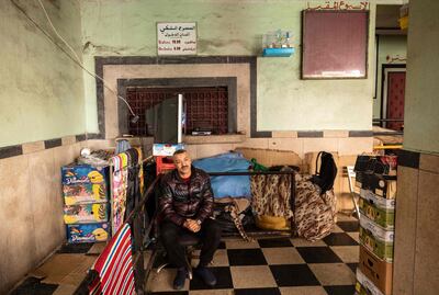 A man sits between boxes piled up at the entrance of the "Al Malaki" cinema, located in the heart of the market in the working-class neighbourhood of Derb Sultan, in the western Moroccan city of Casablanca, on January 24, 2022. - During the coronavirus pandemic, cinemas across Morocco were closed for over a year before reopening in July 2021. But despite nine million dirhams (850,000 euros) of funding for the Moroccan Centre for Cinematography (CCM), which promotes and regulates film, the industry is struggling to extract itself from the crisis. (Photo by FADEL SENNA / AFP)