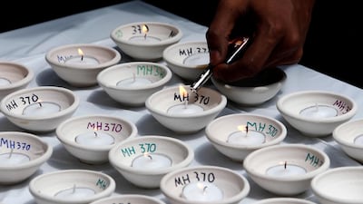 A man lights candles during the fourth annual remembrance event for the missing Malaysia Airlines flight MH370, in Kuala Lumpur, Malaysia March 3, 2018. Lai Seng Sin / Reuters