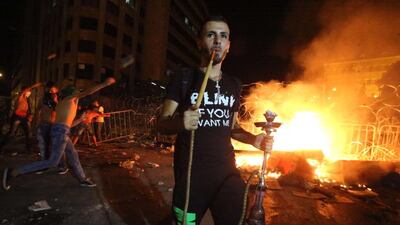 A Lebanese protester smokes a water pipe during clashes with security forces following a demonstration against the ongoing trash crisis, in front of the seat of the government in central Beirut. Lebanon’s cabinet ended an acrimonious meeting with no solution to the rubbish crisis that has sparked violent protests and calls for the government’s resignation. AFP Photo / STR