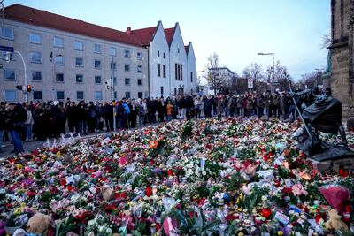 People lay flowers and lit candles in front of the Johannis church close to the Christmas market, where a car drove into a crowd on Friday evening, in Magdeburg, Germany, on December 22. AP