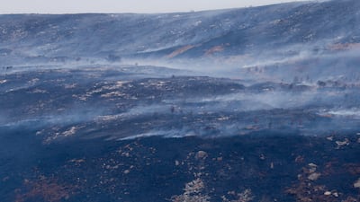 Scorched grassland and smoke rising from the Tintwistle Moor wildfire, near Glossop. Reuters