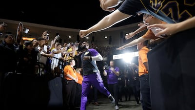 Los Angeles Lakers forward LeBron James runs past fans on his way to the court before an NBA preseason basketball game in San Diego. Gregory Bull/AP Photo
