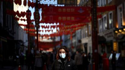A person wearing a protective face mask as protection against coronavirus disease Covid-19 walks through Chinatown in London. Reuters