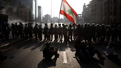Lebanese protesters wave the national flag in front of riot police in the capital Beirut. AFP