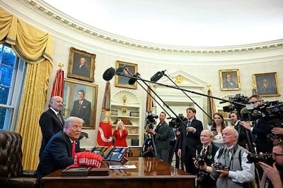 President Donald Trump speaks to the media next to hats reading 'Trump was right about everything', after signing an executive order at the Oval Office of the White House in Washington on February 25. AFP