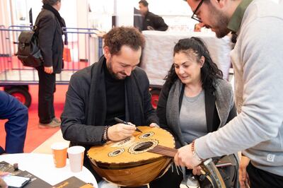 Iraqi musician Naseer Shamma signs an oud to a fan after his session at the Frankfurt Book Fair on October 16, 2019. Courtesy Kalima