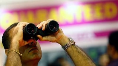 A visitor checks out a pair of binoculars at the Gitex show. Satish Kumar / The National