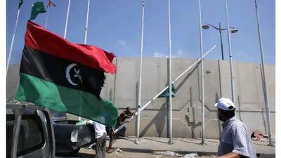The Libyan rebellion's flag flutters as rebels pull down a pole bearing the old regime's green flag at the Abu Slim square in Tripoli.