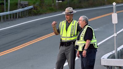 A New York state trooper and a member of the National Transportation Safety Board view the scene of the accident. AP Photo