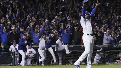 Chicago Cubs relief pitcher Aroldis Chapman celebrates the final out as his teammates rush the field. David J. Phillip / AP