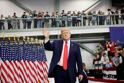 US President Donald Trump waves on stage at the Curtis D. Menard Memorial Sports Centre in Wasilla, Alaska. Reuters