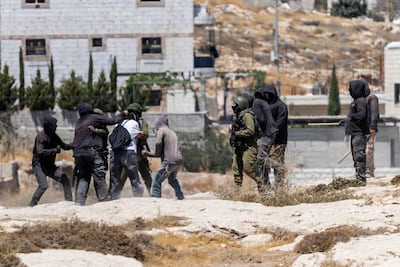 Israeli settlers, some holding sticks, scuffle with left-wing activists as Israeli soldiers intervene at an Israeli outpost in the occupied Palestinian village of Jannatah. AFP