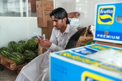 A merchant counts his money and double checks receipts. Victor Besa / The National