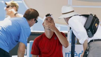 Frank Dancevic of Canada receives medical attention during his men's singles match against Benoit Paire of France. Brandon Malone / Reuters