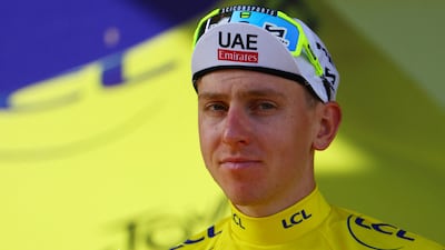 UAE Team Emirates' Tadej Pogacar celebrates on the podium wearing the yellow jersey after Stage 2. Reuters