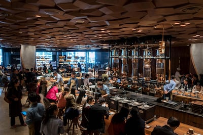 Visitors wait for their coffee at the Starbucks Reserve Roastery outlet in Shanghai on December 6, 2017. AFP