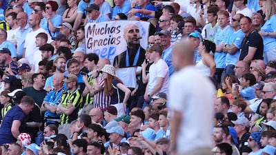A Manchester City fan holds a Pep Guardiola sign in the stands at the Etihad Stadium. PA