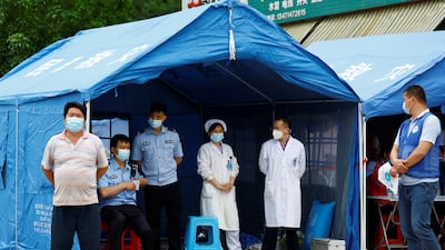 Medical workers and police at Lu village. Reuters