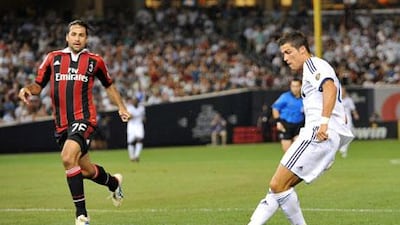 Cristiano Ronaldo knocks the ball past Milan's Mario Zepes to score his second at the Yankees Stadium