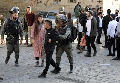 Israeli police push a Palestinian youth away as they guard Israeli settlers touring the old city and market of Hebron. AFP