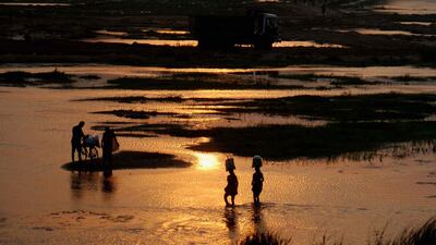 Indian villagers cross the Daya River as they return home after finishing daily marketing on a hot afternoon, on the outskirts of eastern Bhubaneswar, India. Asit Kumar / AFP