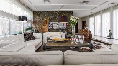 The living area includes a modern living room with a sandstone mosaic wall, a central lobby and a curved central steel staircase. Courtesy Luxhabitat