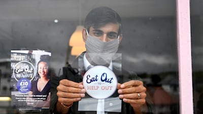 The Chancellor places a 'Eat Out To Help Out' sticker in a cafe window. Sunak has created a number of slogans during the Coronavirus crisis. Getty Images