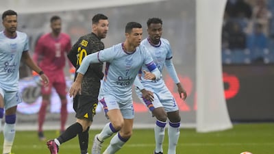 Cristiano Ronaldo is challenged by PSG's Lionel Messi. AP