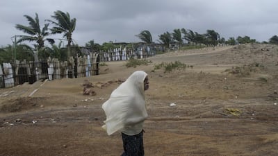 An Indian villager uses a piece of cloth to protect himself from strong winds as he walks through the Bay of Bengal coast at Gopalpur, Odisha. Biswaranjan Rout/AP Photo