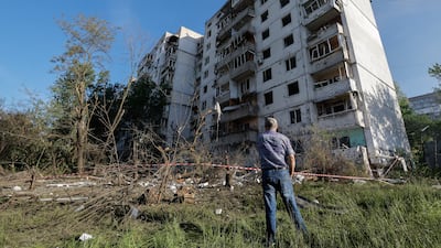 A man looks at damage done to a nine-story residential building and its surroundings in Kyiv. EPA