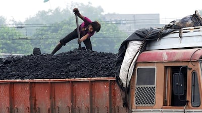 A worker loads coal onto a truck at the Kankaria Railway Yard in Ahmedabad. Sam Panthaky / AFP